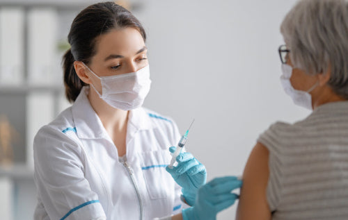 Pharmacist administering a vaccine to a patient in a clinical setting